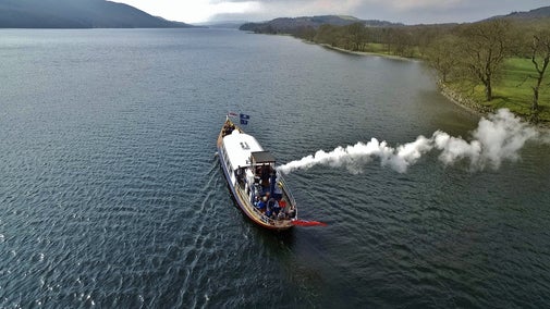 Drone shot from the air looking down at Steam Yacht Gondola sailing up Coniston
